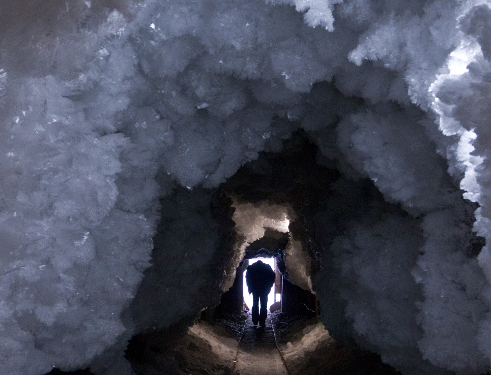 A man walks through a tunnel formed from crystals of permafrost in northeast Russia in 2013. Experts give an overview of the permafrost carbon problem in Nature.