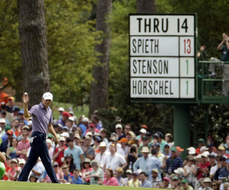 Jordan Spieth holds up his ball after making a birdie on the 15th hole, where the board shows him far ahead of his playing partners Friday in the second round of the Masters.