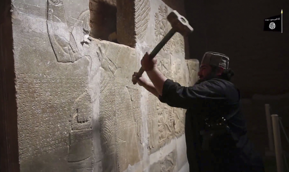 An Islamic State militant takes a sledgehammer to an Assyrian relief at the site of the ancient city of Nimrud in this image from video posted late Saturday. The destruction follows other attacks on antiquities carried out by the group. The attacks have horrified archaeologists and U.N. Secretary-General Ban Ki-moon, who called the destruction at Nimrud “a war crime.”