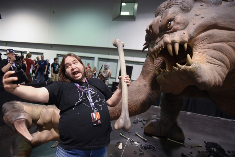 A Star Wars fan takes a selfie with the Roxy the Rancor exhibit Thursday at the Star Wars Celebration at the Anaheim Convention Center.