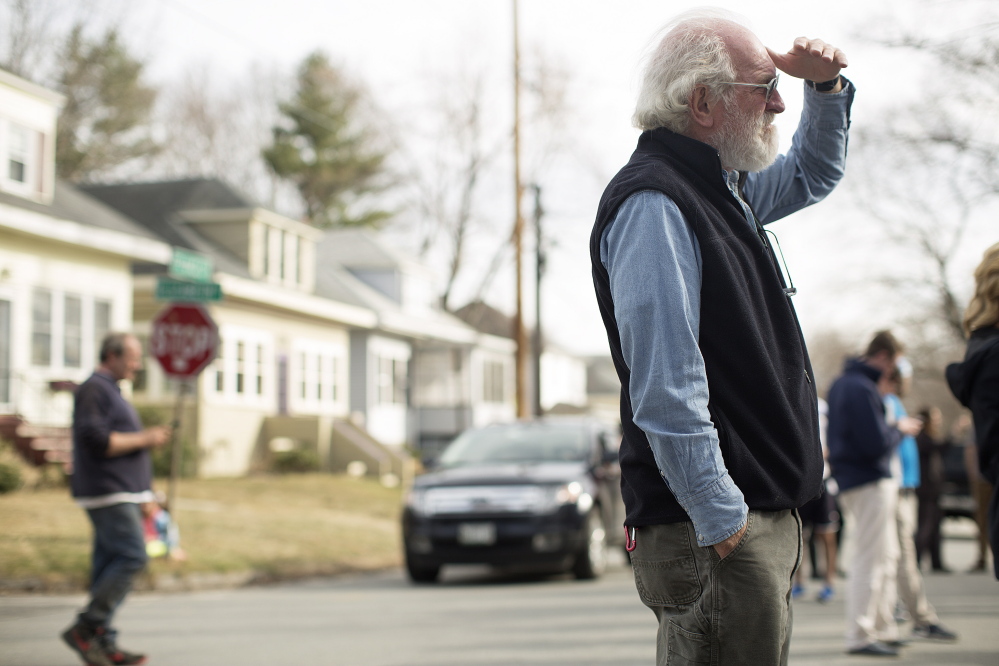 John Murton, who has lived in the neighborhood for 35 years, watches as police gather outside an Elizabeth Road house after a shooting Friday. Yoon Byun/Staff Photographer