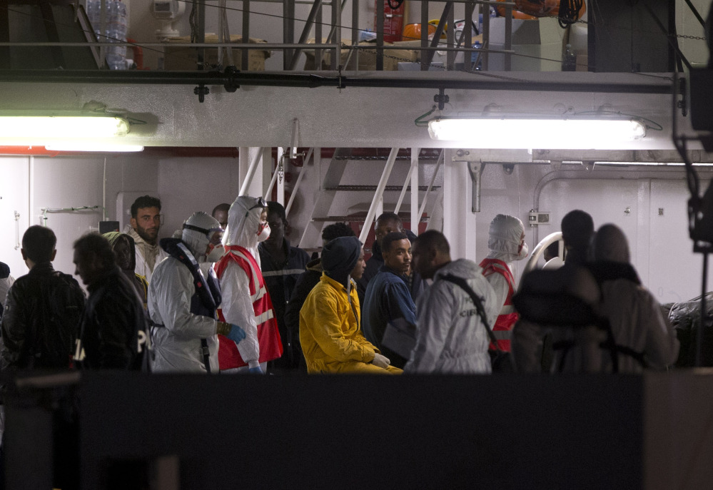 Survivors of the boat that overturned off the coast of Libya Saturday wait to disembark from Italian Coast Guard ship Bruno Gregoretti, at Catania Harbor, Italy, on Monday.