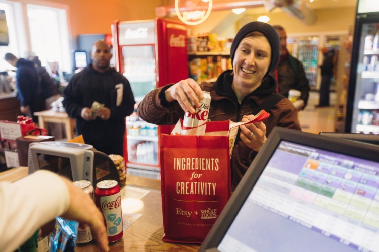 Morgan McCormack places soda into a reusable bag at Colucci’s Hilltop Superette on Congress Street on Monday. McCormack says she brought reusable bags to the store prior to the city’s new policy, but the new fee is “definitely a reminder.”