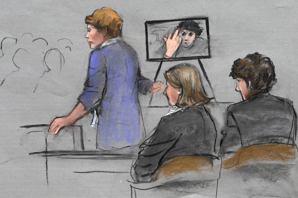 In this courtroom sketch, prosecutor Nadine Pellegrini makes opening arguments during the first day of the penalty phase in the trial of Boston Marathon bomber Dzhokhar Tsarnaev, seated at right, Tuesday in federal court in Boston. Pellegrini displayed a photo to the jury of Tsarnaev extending his middle finger to a security camera taken in his jail cell three months after the attack.
