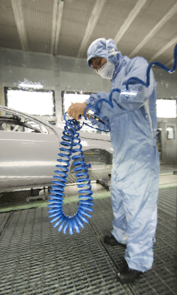 An autoworker washes car body frames in a Volvo factory in Chengdu, in China’s Sichuan province. In June, “Made in China” Volvos will be exported to the U.S.