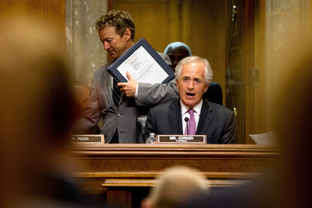 Republican Presidential candidate,and Senate Foreign Relations Committee member, Sen. Rand Paul, R-Ky, left, passes Committee Chairman Sen. Bob Corker, R-Tenn., on Capitol Hill in Washington, Tuesday, April 14, 2015, during the committee'smeeting to debate and vote on the Iran Nuclear Agreement Review Act of 2015. Republican and Democrats on the Senate Foreign Relations Committee reached a compromise Tuesday on a bill that would give Congress a say on an emerging deal to curb Iran's nuclear program. (AP Photo/Andrew Harnik)
