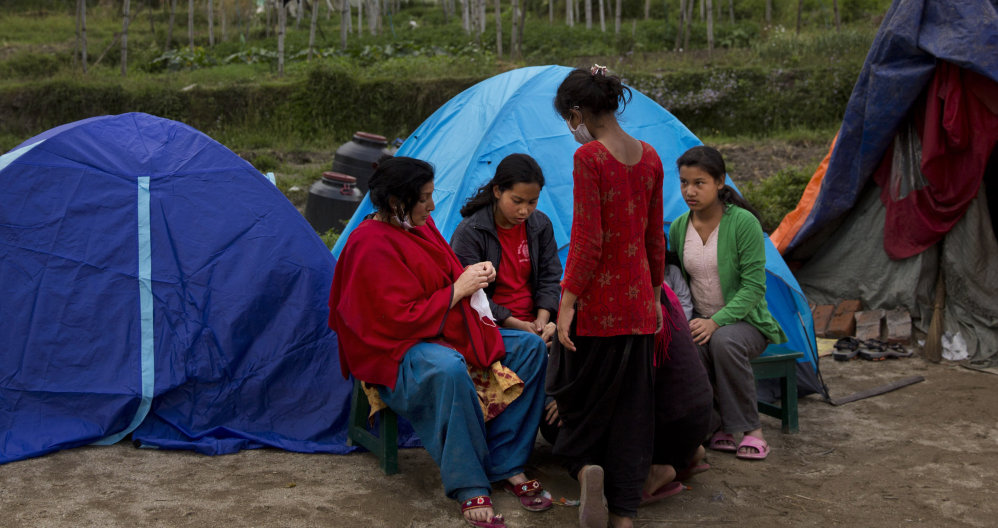 Nepalese villagers gather by tents where they have taken shelter in Sakhu, on the outskirts of Kathmandu, Nepal, on Wednesday. People fear being inside buildings.