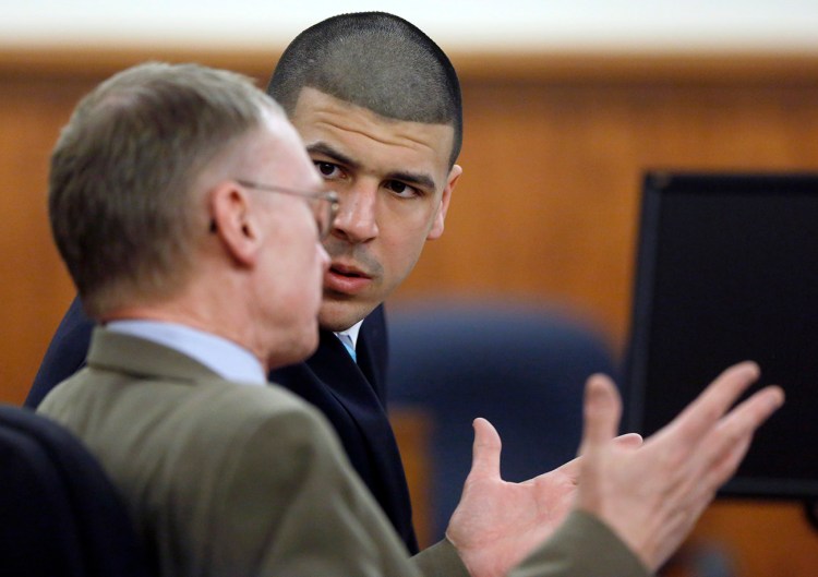 Aaron Hernandez listens to his defense attorney Charles Rankin as the judge and attorneys for both sides discuss questions from the jury deliberating Hernandez's fate, Thursday in Fall River, Mass. The Associated Press