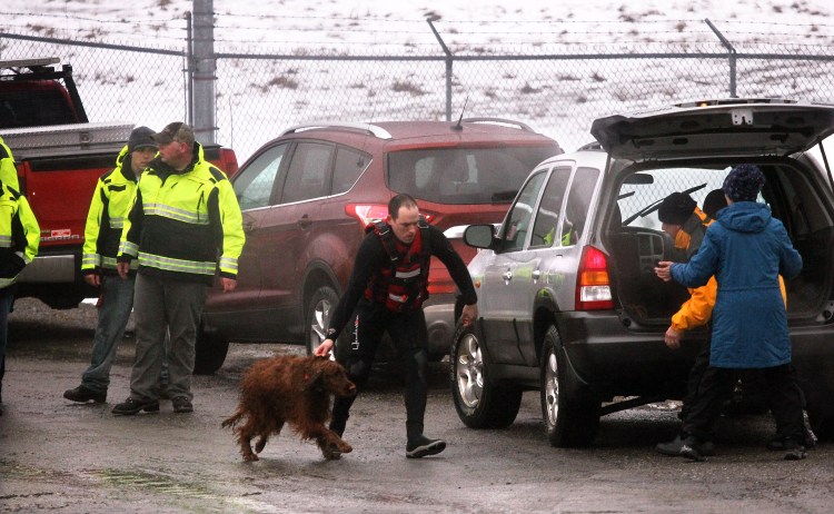 An Irish Setter is delivered to its owners shortly after being rescued from the icy waters of the Kennebec River in Winslow on Friday.
