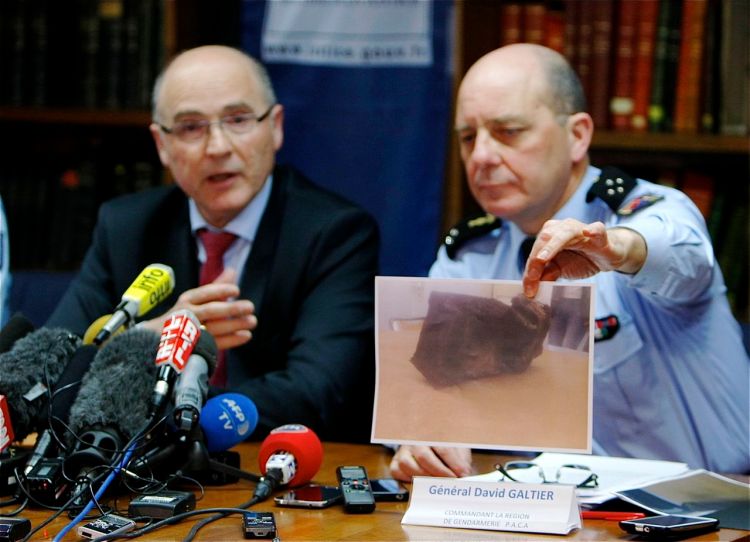 Gen. David Galtier displays a photo of the second black box from the Germanwings plane that crashed in the French Alps last week. Marseille prosecutor Brice Robin, left, said a gendarme found the  box blackened and buried in the mountainside at the crash site Thursday. The Associated Press