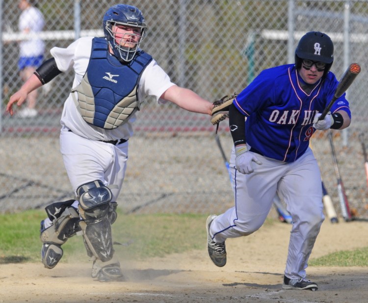 Dirigo catcher Tyler Frost, left, tags out Oak Hill’s Adam Mooney as he tries to leg out a dropped third strike during a Mountain Valley Conference game Friday in Wales.