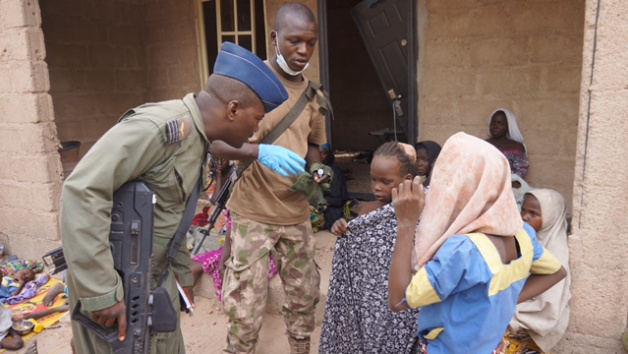 A Nigerian soldier speaks to woman and children that were allegedly rescued by the Nigerian Military after being taken by Islamic extremists in Sambisa Forest, Nigeria.