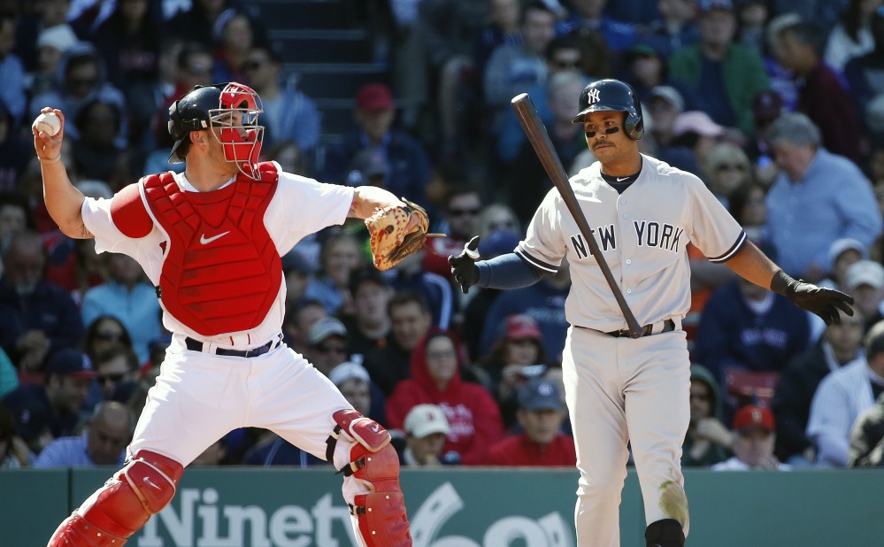 Boston Red Sox’s Blake Swihart, left, throws back to the mound as New York Yankees’ Gregorio Petit, right, tosses his bat after striking out during the seventh inning Saturday in Boston. Swihart collected his first hit in his major league debut but the Yankees won 4-2.