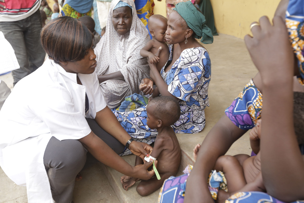 A doctor attends to a Malnourished child as women and children rescued by Nigerian soldiers wait to receive treatment at a refugee camp in Yola, Nigeria Sunday after being rescued from captivity by Boko Haram fighters.
