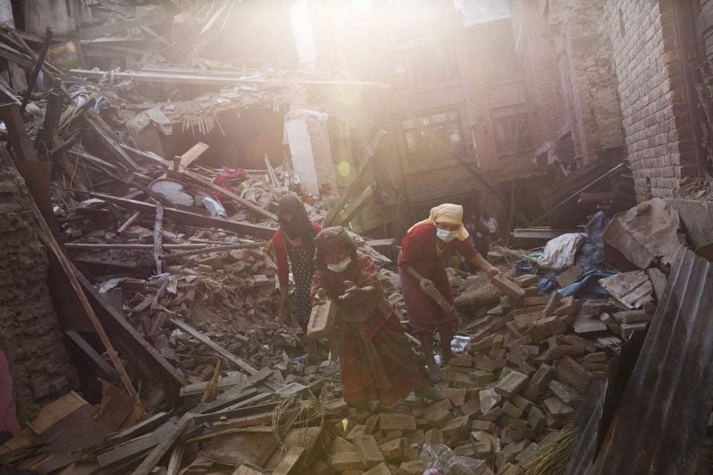 Nepalese woman remove debris searching their belongings from their house that was destroyed a week ago during the earthquake in Bhaktapur, Nepal, Sunday.