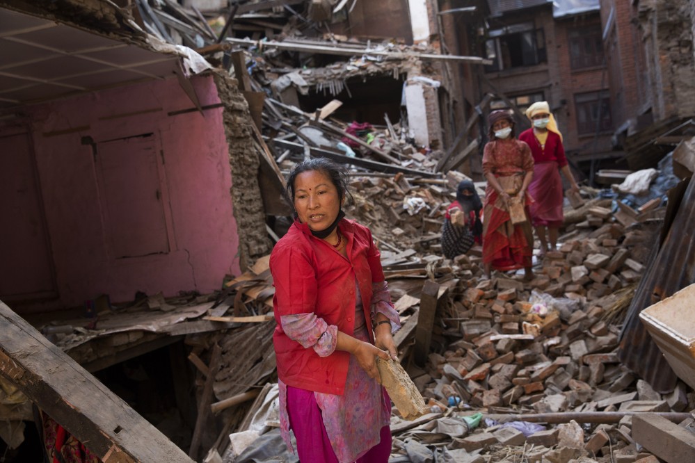 Nepalese women remove debris searching their belongings from their house that was destroyed a week ago during the earthquake in Bhaktapur, Nepal, Sunday.