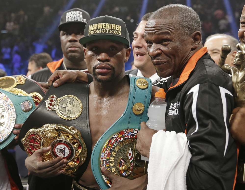 AP photo
Floyd Mayweather Jr., left, poses with his champion’s belts and his father, head trainer Floyd Mayweather Sr., after his victory over Manny Pacquiao  in their welterweight title fight Saturday in Las Vegas.