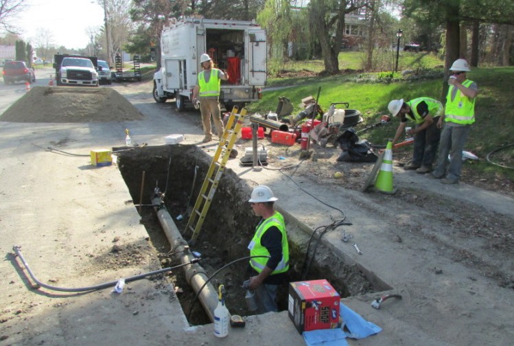 Employees from ETTI, a utilities construction company from Lisbon Falls, replace an electrofusion tee on a Summit Natural Gas line on Cool Street in Waterville Monday afternoon.