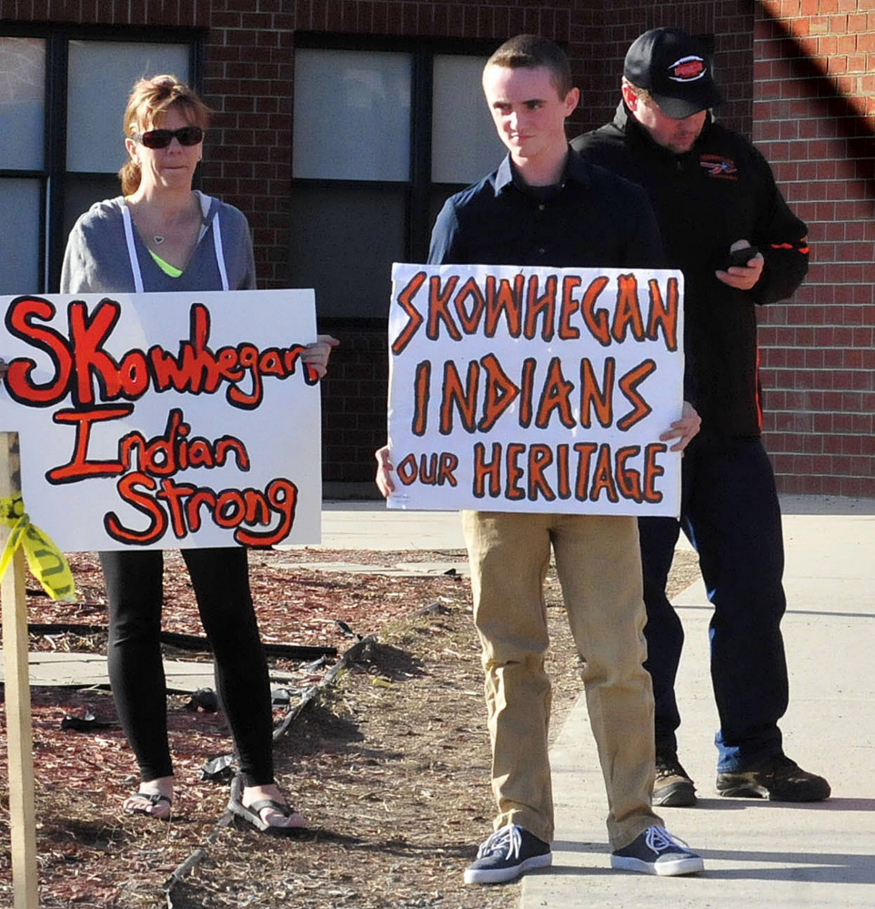 Zach Queenan, holding a sign at right, during a rally in April. Queenan has now changed his mind and is supporting the effort to stop using Indians as a mascot.
