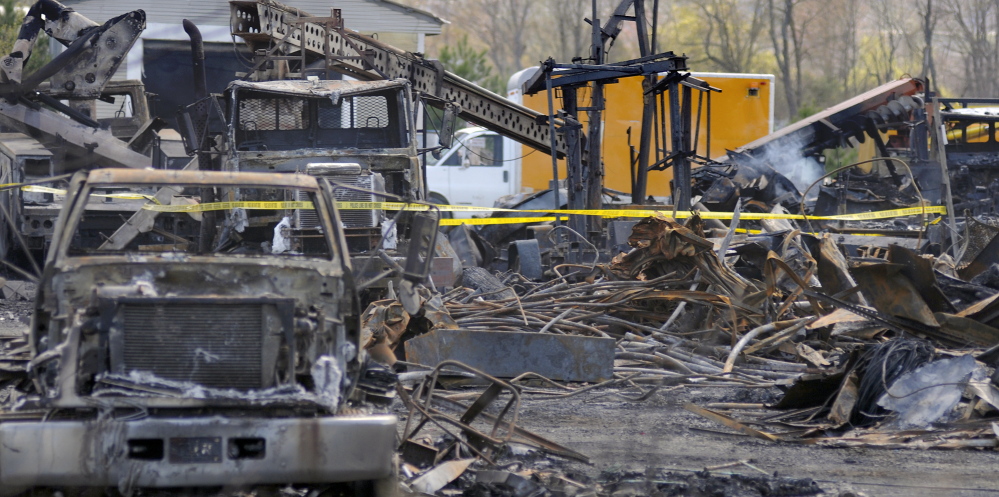 The AD Electric site in Monmouth on Wednesday consisted of charred vehicles and a burned building. The Office of the State Fire Marshal and the Maine Department of Environmental Protection are investigating Tuesday’s fire.