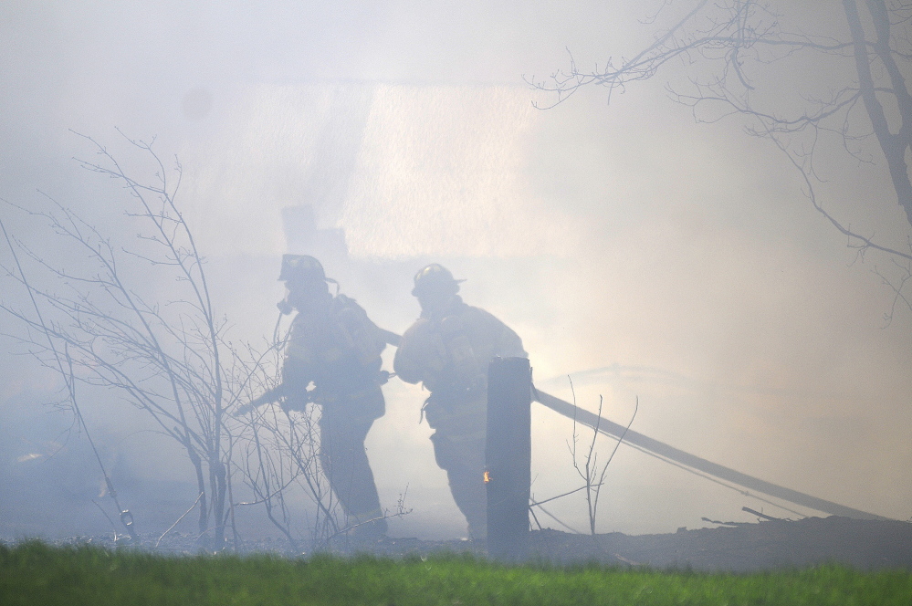 Firefighters on Tuesday try to approach the blaze that destroyed AD Electric on South Monmouth Road in Monmouth. The Office of the State Fire Marshal and the Maine Department of Environmental Protection are investigating the fire.