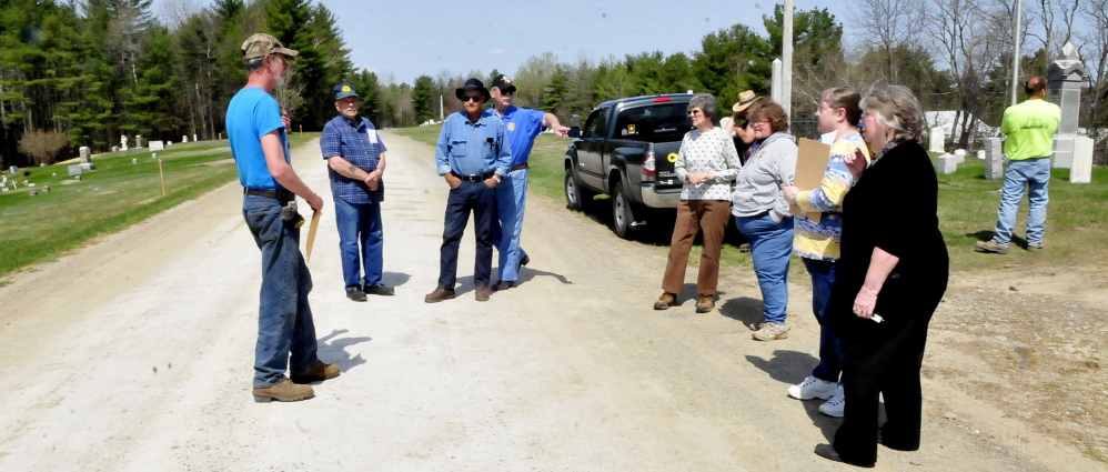 A group of Unity residents assemble on Thursday at the Pond Cemetery in an effort to convince the town to repave Kanokolus Road this summer. They argue that the road is the source of gravel and dust that litters the grave sites. There are times when debris is so thick that mowers will not use cutting equipment to maintain grass.