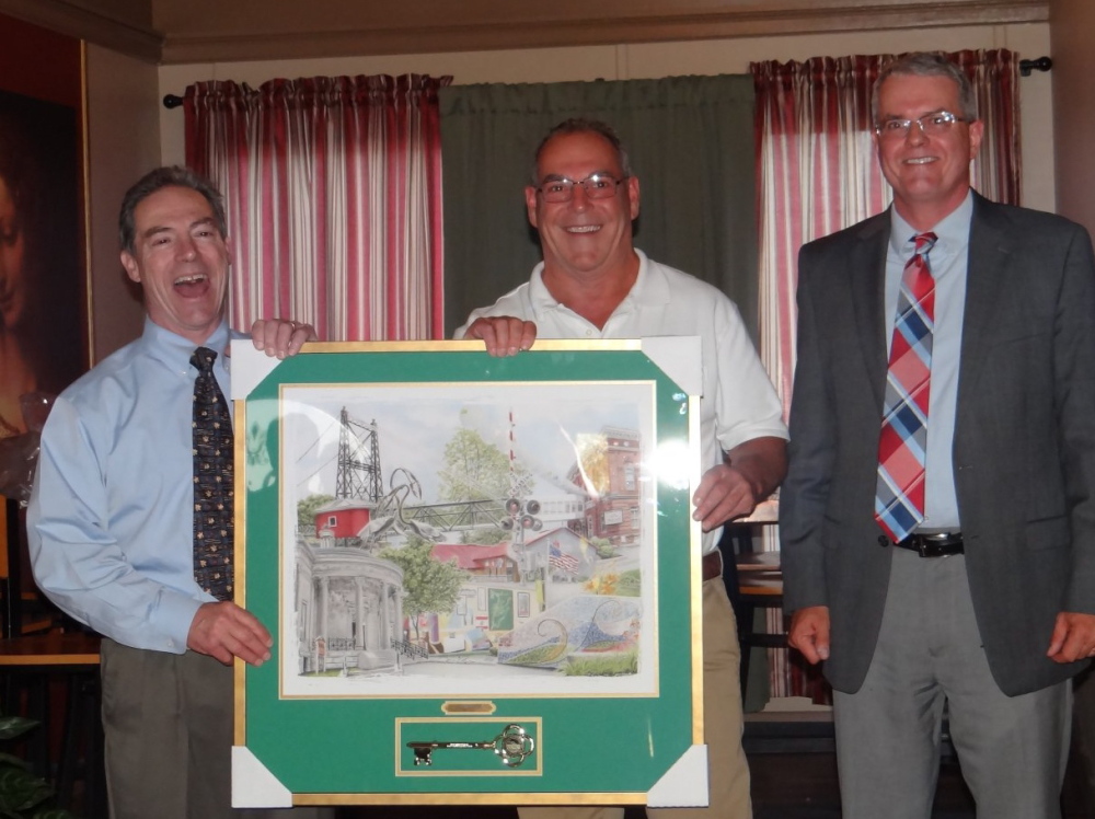 Waterville City Manager Mike Roy (right) and Downtown Main Street President Ronald Ducharme (left) present the Downtown Business of the Year Award to Silver Street Tavern owner Charlie Giguere Thursday at Amici Cucina in Waterville.