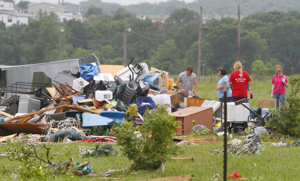 Neighbors and friends help clean up after Thursday night’s tornado passed the area on Friday in New Fairview, Texas.