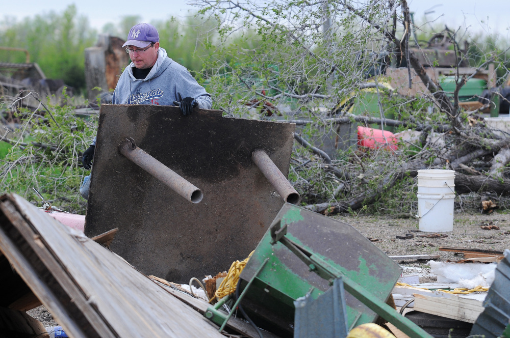 James Fink surveys the damage to family friend Mike Fechner’s farm on Sunday near Delmont, S.D., after a tornado tore through the area damaging homes and businesses on Sunday morning.