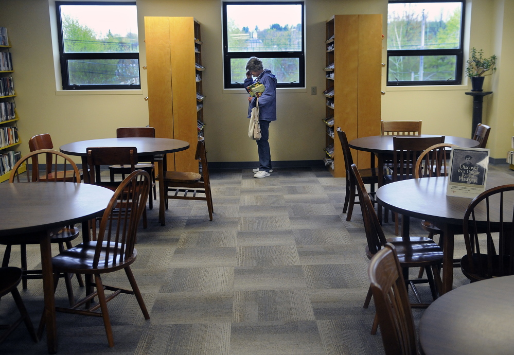 A woman browses at the temporary location of Augusta’s Lithgow Public Library that opened Monday for what’s expected to be an 18-month stint at the Ballard Center on Augusta’s east side.