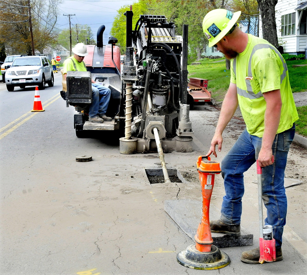 Subcontractors for Summit Natural Gas of Maine guide a drill under the surface of North Street in Waterville on Tuesday while work continues on the company’s natural gas pipeline system in Waterville.