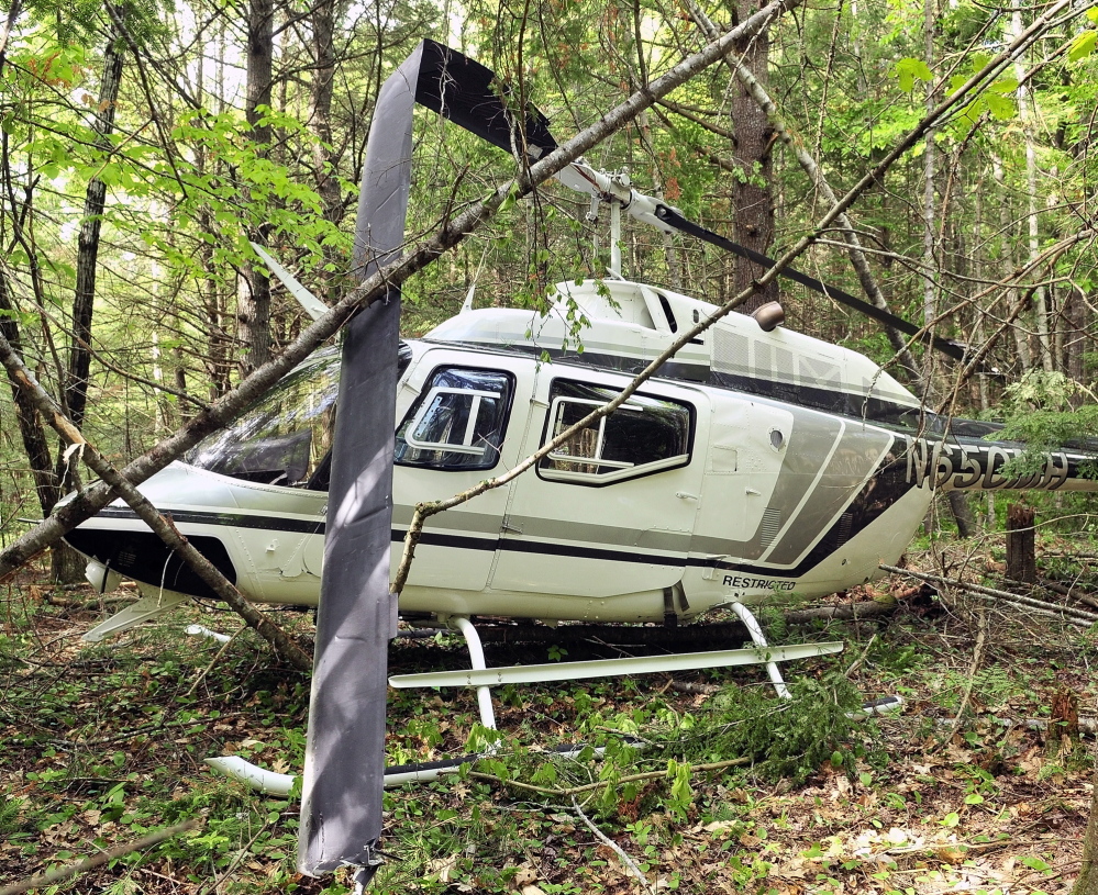 A helicopter sits in the woods after a crash landing on Friday May 30, 2014, in Whitefield.