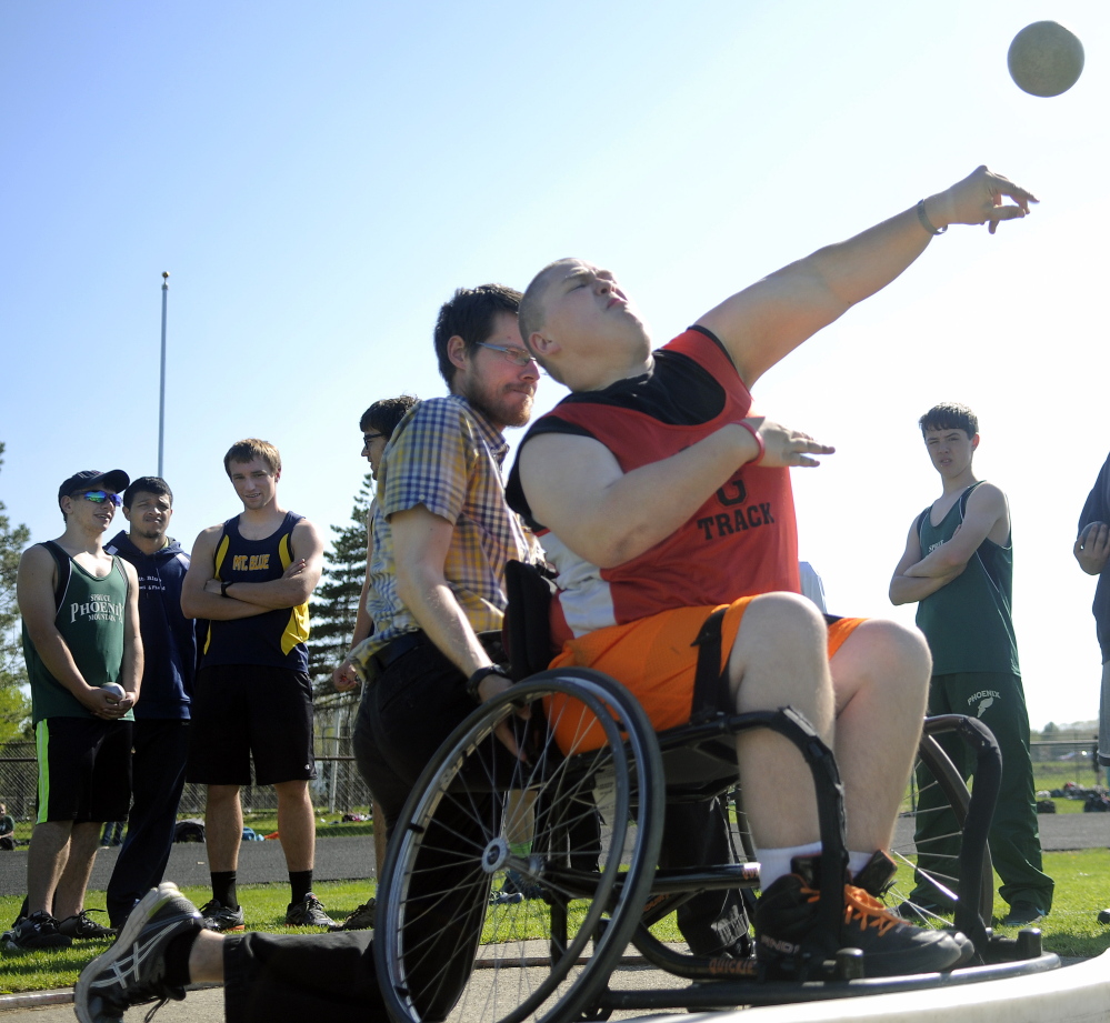 Staff photo by Andy Molloy 
 Anchored by assistant coach Joe Fitzsimmons, Gardiner Area High School student RJ Sullivan competes in the shot put during a meet Thursday in Gardiner.
