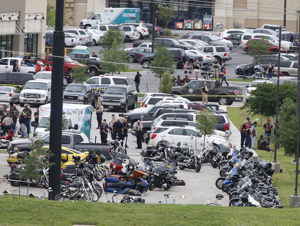Law enforcement officers investigate a shooting in the parking lot of the Twin Peaks Restaurant Sunday in Waco, Texas.