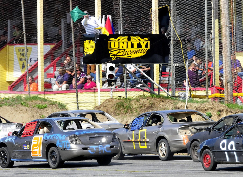 Unity Raceway flagger Jeff Overlock waves the green flag to restart the first Super Stock Enduro race during the season opener Sunday in Unity.