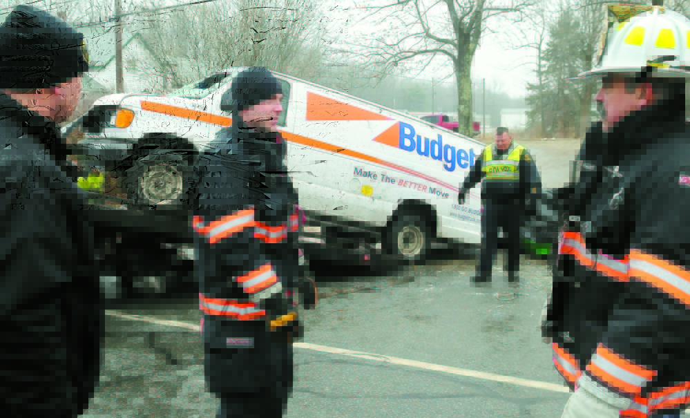 Gardiner police and firefighters remove a van that rolled over Dec. 31, 2011, and claimed the lives of two men and injured a third on ice-covered U.S. Route 201 in Gardiner.