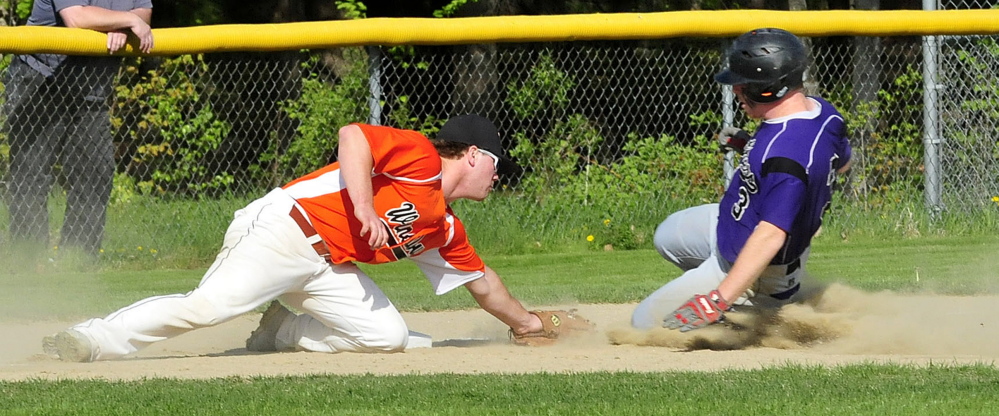 Winslow’s Dylan Hapworth, left, tags out Waterville baserunner Dan Pooler during a game Monday in Winslow. The Black Raiders beat the Purple Panthers 5-0.