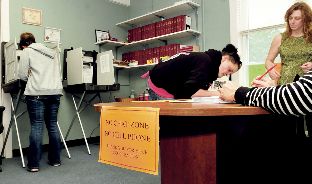 Resident Cora Reny, left, casts her ballot as Amanda Bourdeau registers to vote while Fairfield Town Clerk Christine Keller observes during voting for the school budget on Tuesday.