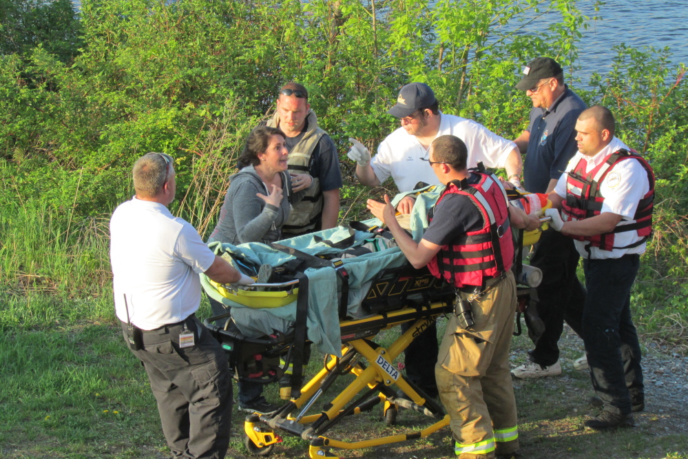 A woman argues with emergency medical personnel near the Two Cent Bridge in Waterville after a male acquaintance was rescued from the bank of the Kennebec River in Winslow on Tuesday.