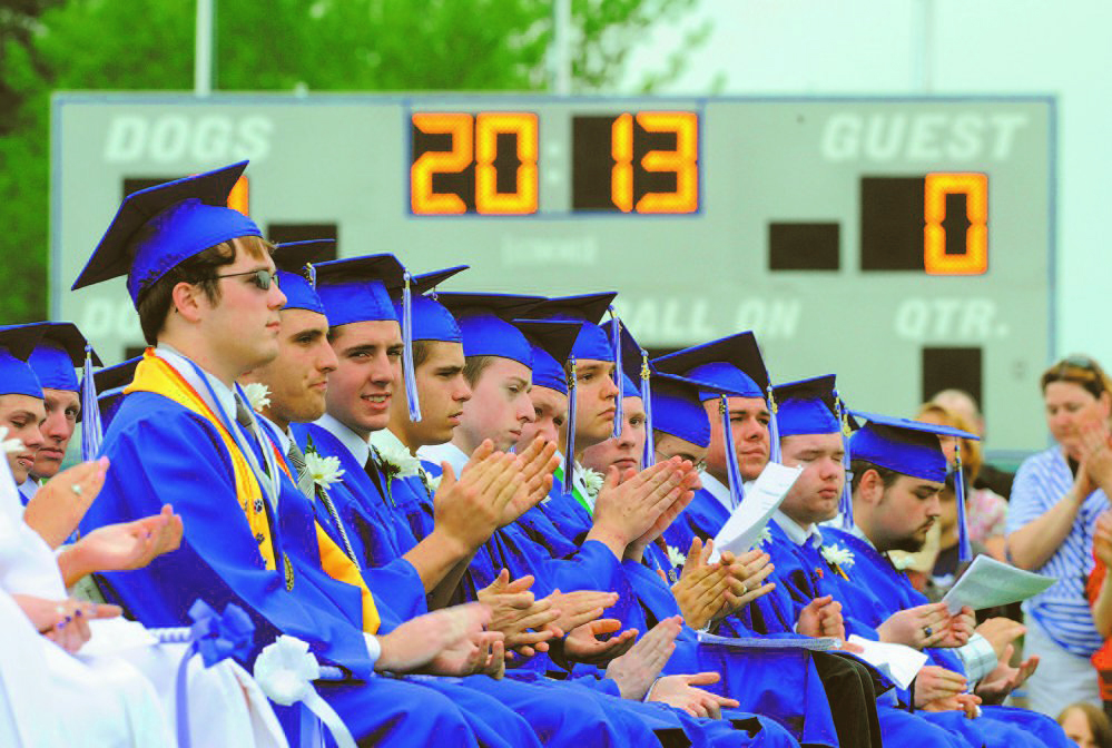 Graduates applaud during the 2013 commencement ceremony at Lawrence High School in Fairfield. School Administrative District 49 voters on Tuesday rejected the budget for the district, which also includes Albion, Benton and Clinton. The school board chairman said he would advocate for sports funding to be cut before teachers are laid off.