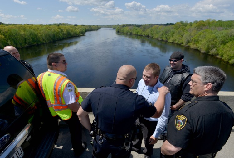 Police officers and firefighters from Waterville and Winslow stand on Carter Memorial Bridge after a report that a man seen on the bridge possibly jumped off it Friday morning. Emergency responders looked in the river, but found nothing.