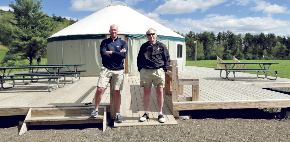 Matt Skehan, left, director of Waterville Parks and Recreation, and John Koons stand in front of a yurt on Wednesday at the Quarry Road Recreation Area in Waterville. Officials are trying to raise the final part of a Harold Alfond Foundation grant match to complete upgrades at the site.