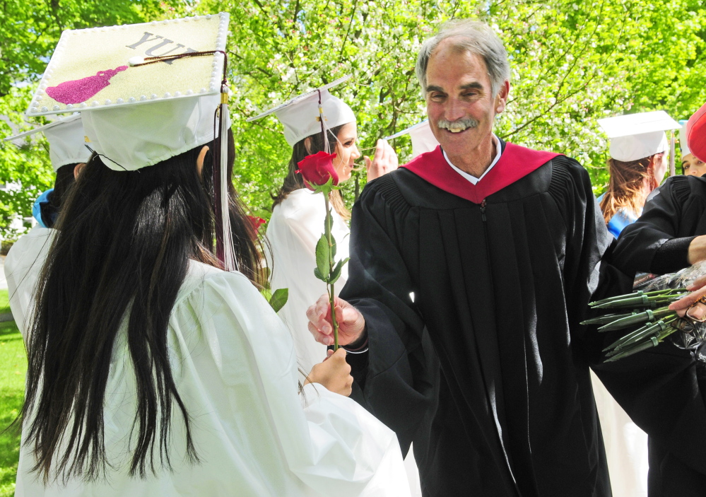 Kents Hill School head of school Pat “Mr. Mac” McInerney hands out roses to senior girls before the school’s graduation ceremony Saturday in Readfield.