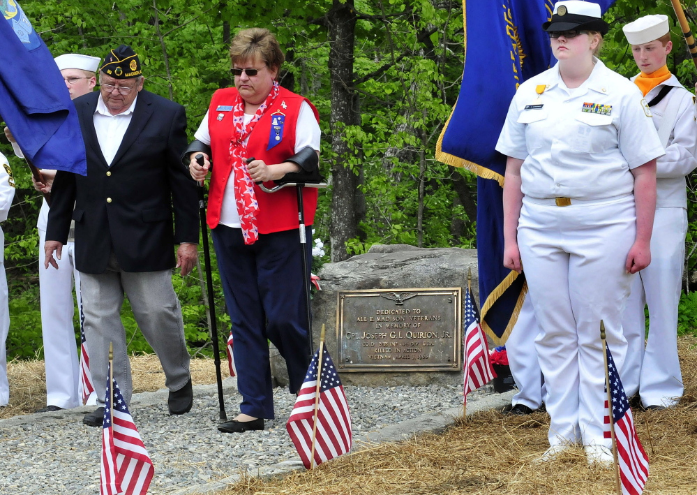 Earl Beaulieu and Robin Turek walk away after placing a wreath at the new Joseph Quirion Jr. war memorial created at the site of the former East Madison store on Monday.