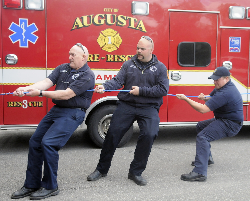 Augusta Fire Department paramedics Randy Gordon, left, Jeremy Manzer and Kurt Gordon get pulled inside Hartford Fire Station in Augusta by colleagues during training last week. The Department is celebrating 40 years of providing emergency medical services in the community. The course, taught by Randy Gordon, instructed paramedics on how to rescue the injured with ropes.