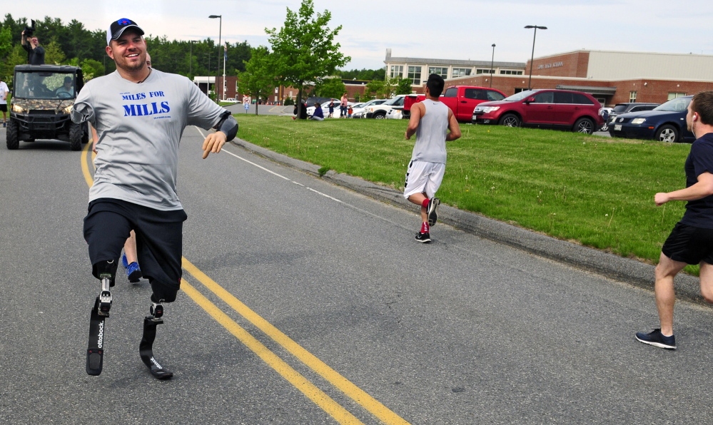 Travis Mills, of Manchester, waves to other participants as he takes part in the fourth annual Miles for Mills 5K on Monday at Cony High School in Augusta. Proceeds from the event will benefit the Travis Mills Foundation, a nonprofit organization, formed to benefit and assist wounded and injured veterans.