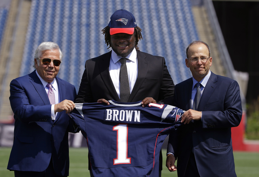 Defensive lineman Malcom Brown, the New England Patriots first round draft pick, center, poses with Patriots owner Robert Kraft, left, and Patriots president Jonathan Kraft on Wednesday at the team’s facility in Foxborough, Mass.