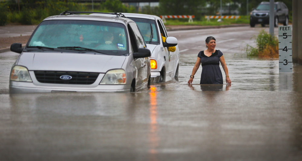 The Associated Press A city of Brownsville vehicle pushes a stranded van that attempted to make it through the high waters as a woman walks along side them along Mexico Boulevard in Brownsville, Texas, Thursday.