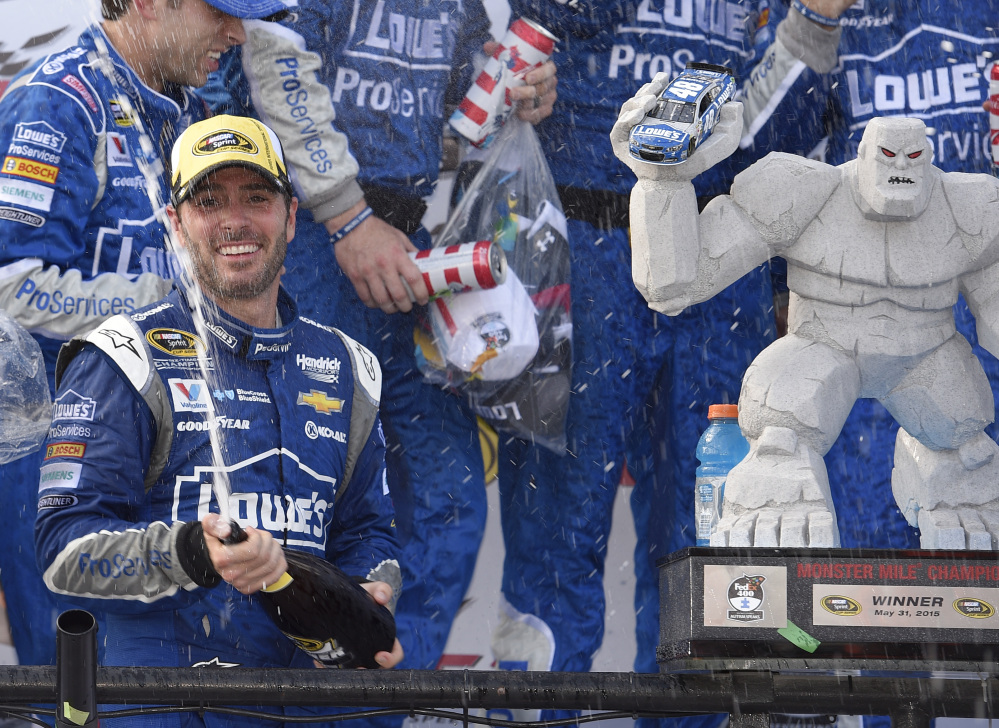 Jimmie Johnson sprays sparking wine as he celebrates in Victory Lane on Sunday after he won the NASCAR Sprint Cup race at Dover International Speedway in Dover, Del.