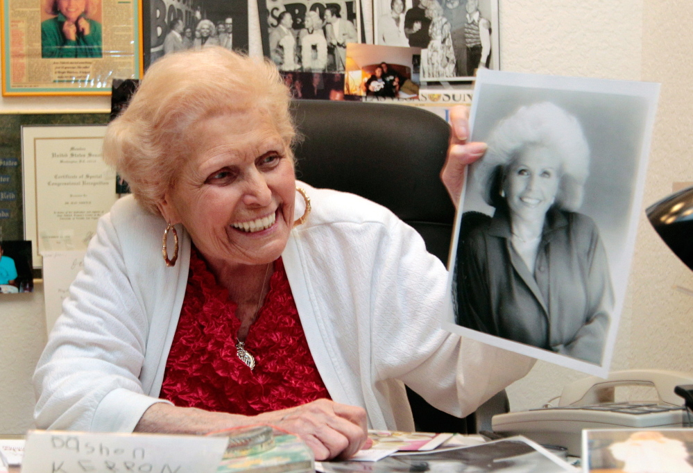 Weight Watchers co-founder Jean Nidetch holds a photo of her younger self. She believed that emotional support and certain eating principles helped people drop pounds.